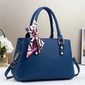 Detail of navy blue pebble leather handbag featuring gold hardware and patterned silk scarf - Blue / L29 W13 H21