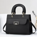 Détail de la texture litchi noire sur un sac à main chic pour femme avec fermoir doré - Noir