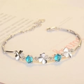 Pulsera de trébol s925 de plata con circonitas azules sobre fondo de papel beige - Circonita Azul Mar