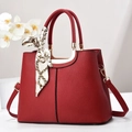 Elegant red pebbled leather handbag with gold metal hardware and silk scarf decoration - Red