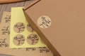Runde braune Kraftpapier Thank You Aufkleber auf einem Versandkarton aus Wellpappe - Einfacher Danke-Stil