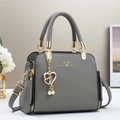 Elegante bolso de mano gris oscuro con herrajes dorados y un colgante de perla y corazón - Gris