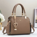 Macro detail of brown lychee grain leather handbag with gold heart pearl charm - Dark Khaki