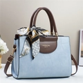 Detalle de bolso bandolera azul claro con asa marrón y pañuelo decorativo de seda - Azul