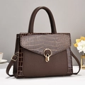 Detail of dark brown tote bag with crocodile texture stitching and golden ring lock - Coffee