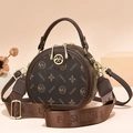 Brown monogrammed round crossbody bag with leather handle and woven textile strap - Coffee