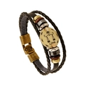 Macro detail of Libra zodiac bronze charm on multi-layer black braided leather bracelet - Libra