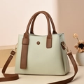 Elegante borsa a trapezio in pelle beige con manici marroni e dettagli dorati - verde chiaro