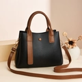 Dettaglio della borsa a tracolla in pelle nera litchi con finiture in pelle marrone - Nero