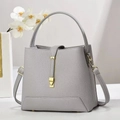 Detail of grey pebble leather bucket bag with gold buckle and circular top handle - 23x12x21cm / Gray