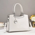 Detailaufnahme der weißen Lederhandtasche mit Schwanenanhänger und silbernem Metall - Weiß