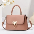 Close-up of pink leather crossbody bag featuring a golden double heart metal lock - Length 24 Width 8 Height 16 / Pink