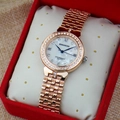 Détail macro de montre or rose avec lunette en strass sur un coussin doux - Or rose