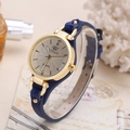 Close-up of elegant women's quartz watch with gold case, silver dial and blue leather strap - Blue