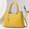 Macro view of yellow litchi leather bag texture with star pearl charm and metal handle - Bright Yellow