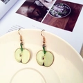 Detailed view of green apple cross-section earrings with glossy finish and gold metal edges - Apple