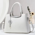 Detalle del bolso de cuero blanco con patrón de litchi, herrajes plateados y colgante de estrella - Blanco Puro