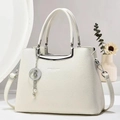 Detalle de bolso de piel blanca con herrajes plateados y un colgante de estrella - Blanco Roto