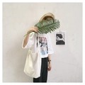 Détail d'un sac cabas en toile de coton blanc cassé avec un t-shirt graphique vintage - Blanc