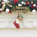 Red Christmas stocking with Santa 3D figure and plaid cuff hanging on a festive tree - Santa Claus