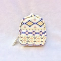 Close-up of a mini backpack coin purse with colorful ethnic geometric canvas patterns - White
