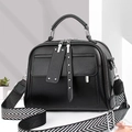 Detail van zwarte PU-leren tas met dubbele ritsen en een geweven stoffen schouderband - Zwart