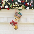 Plaid Christmas stocking with snowman design hanging on a festive decorated white fireplace - Snowman