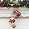 Christmas stocking with 3D Santa Claus and plaid cuff hanging on white brick wall - Santa Claus