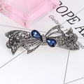 Macro detail of retro silver bow hair clip with blue gemstones and hollow floral patterns - Bowknot Hollow - Sapphire Blue
