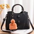 Dettaglio borsa in pelle nera con toppe floreali, cuciture a onda e ciondolo di peluche - Nero