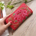 Ethnic style long red wallet with peony embroidery and heart zipper on wooden background - Red