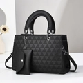 Sac à main noir avec texture géométrique et poignées rondes sur fond gris neutre - Noir