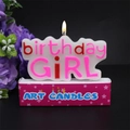 Pink and red 'Birthday Girl' cake candle lit on a star pattern base box - Birthday Girl Candle