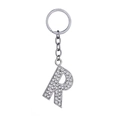 Sparkling silver keychain with rhinestone-encrusted letter R pendant on white background - Letter R
