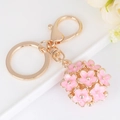 Portachiavi con sfera di fiori rosa in lega dorata e moschettone su sfondo bianco - Rosa