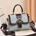 Detalle de bolso verde menta con textura de cocodrilo y correa tejida geométrica - verde claro