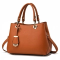 Vue détaillée du sac à main orange en cuir avec breloque cœur et rivets dorés - Jaune Terre