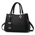 Vue détaillée du cuir noir grainé litchi avec breloque florale dorée sur le sac à main - Noir