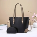 Black leather tote bag with brown straps and matching small pouch on a clean surface - Black