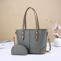 Detail of grey pebbled leather tote bag and matching pouch with golden hardware - Gray