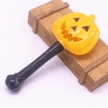 Detail of a glowing Halloween pumpkin magic wand with a yellow head and black handle - Triangle Pumpkin Wand