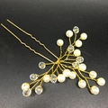 Dettaglio forcina dorata per sposa con perle bianche e cristalli su fondo nero - Oro