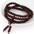 Détail de perles de prière en bois rouge foncé multicouches avec nœud chinois sur plat - 108 Perles de Prière Multi-couches / Rouge