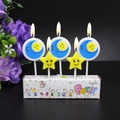 Set of lit blue moon and yellow star smiley face birthday candles on a white base - Moon and Star Candle