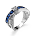 Silver criss-cross ring featuring a dark blue princess-cut zircon and white side stones - Sapphire Blue