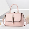 Pink lychee textured crossbody bag with gold hardware on white geometric pedestals - Pink