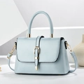 Minimalist baby blue crossbody bag with top handle and gold hardware on white stand - Blue