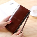 Women's long brown glossy leather wallet with zipper closure and wrist strap - Brown