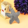 Detail of silver rhinestone starfish keychain with grey tassel and gold metal hardware - Gold Grey