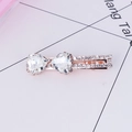 Sparkling rose gold hair clip with heart-shaped rhinestones and crystal bow design - White